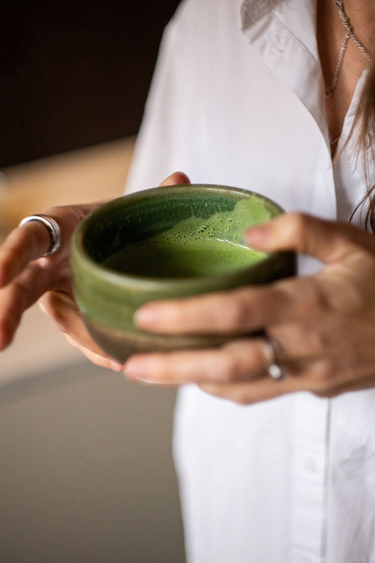 A bowl of matcha being whisked by hand at home.